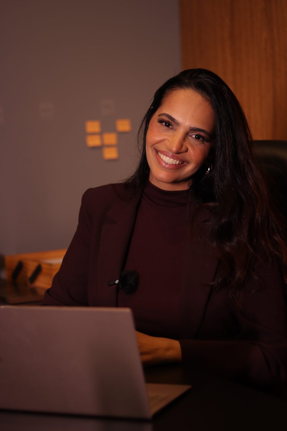 Consultora da Brini Corretora sorrindo em seu escritório